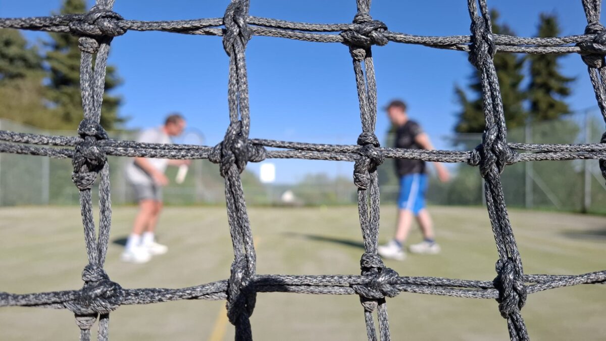Trainingssituation durchs Tennisnetzt